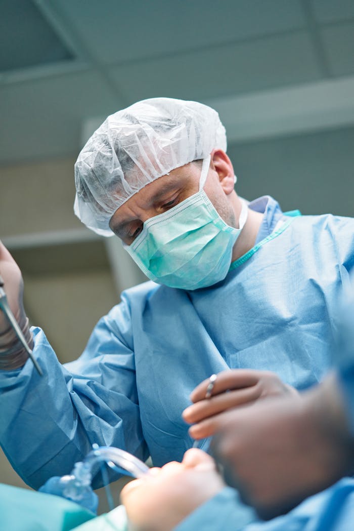 our-story Focused surgeon performing a procedure in a modern operating room with sterile attire.