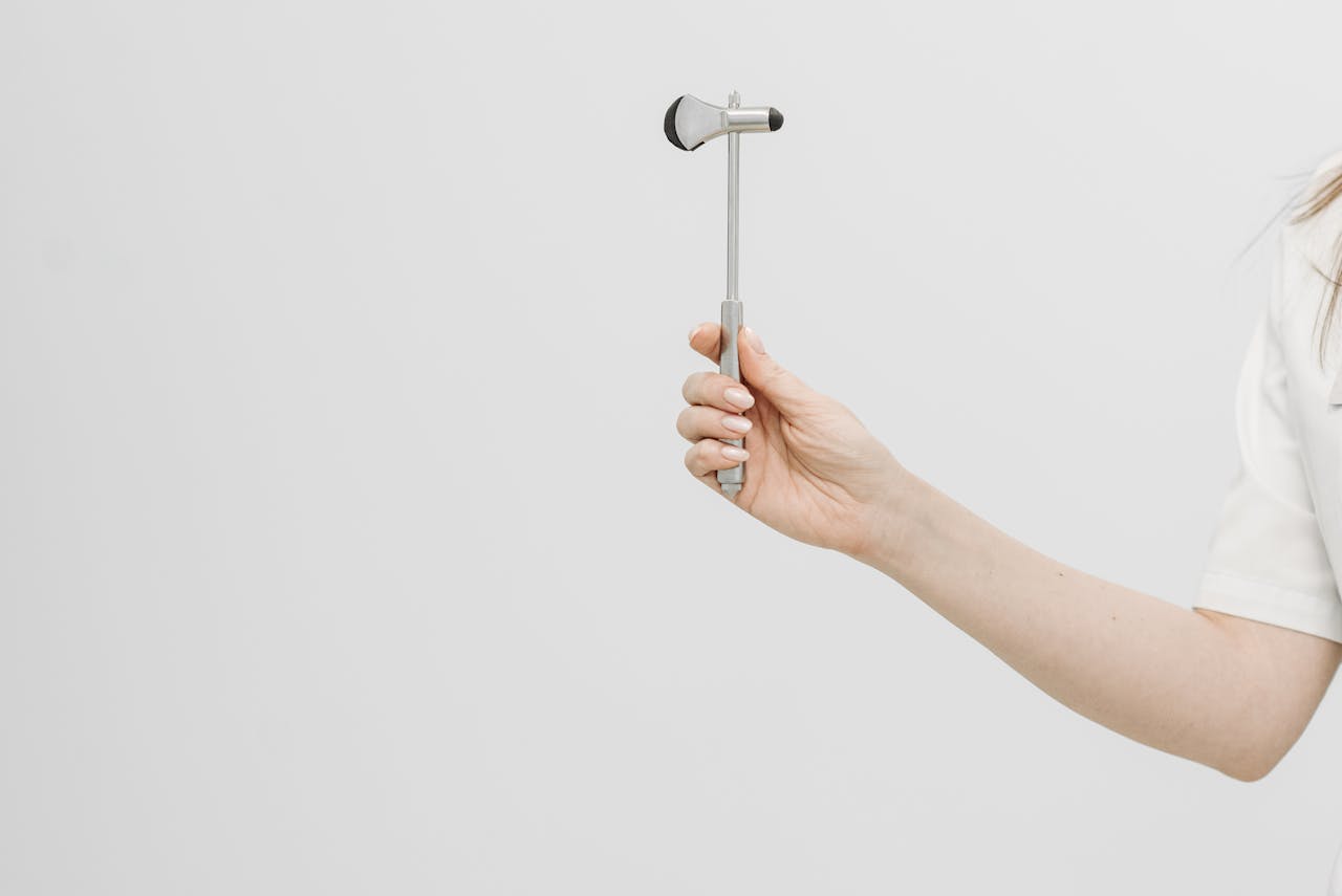 creative-02 Detailed view of a reflex hammer held by a healthcare professional.