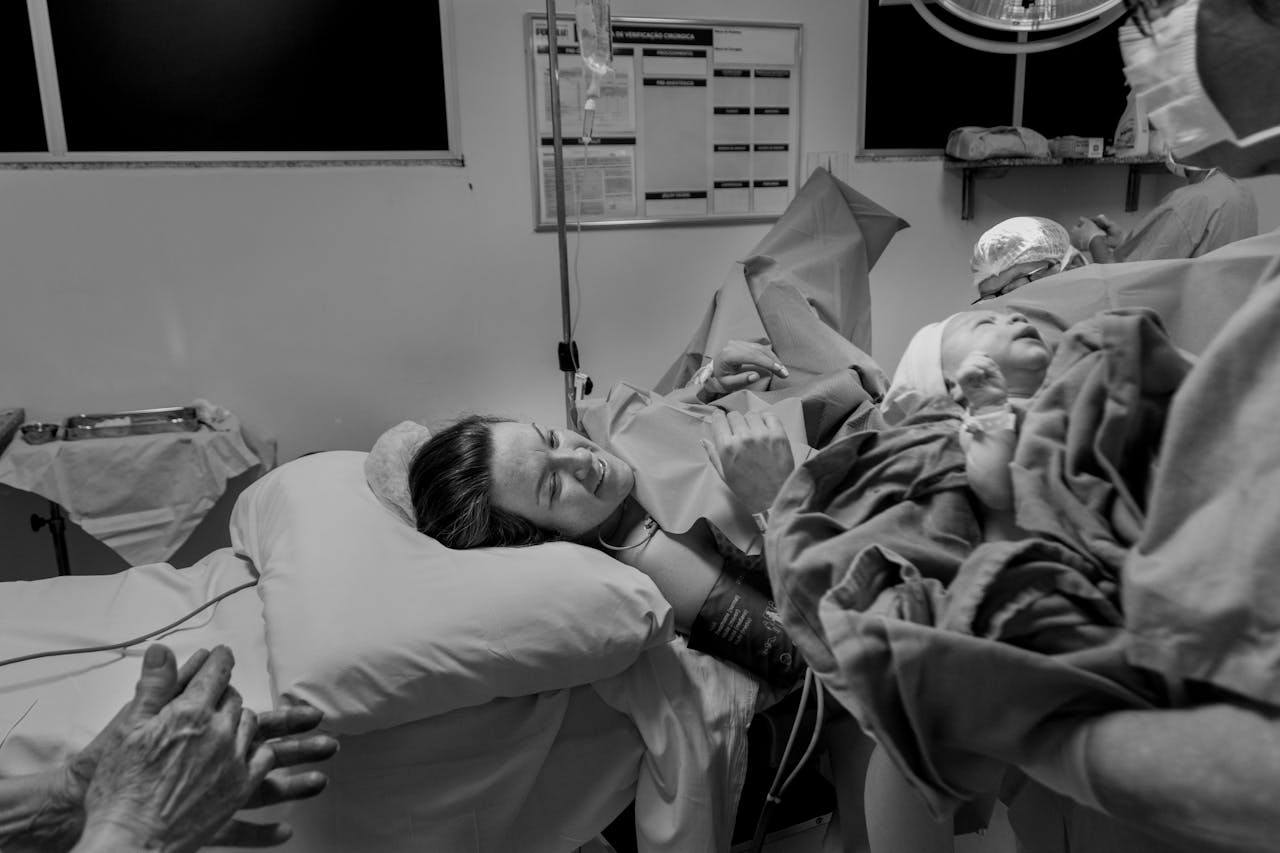 creative-02 Black and white photo depicting a mother meeting her newborn in the delivery room.