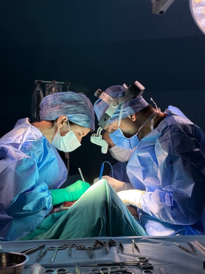 Two surgeons focused on a delicate medical procedure in a hospital operating room.